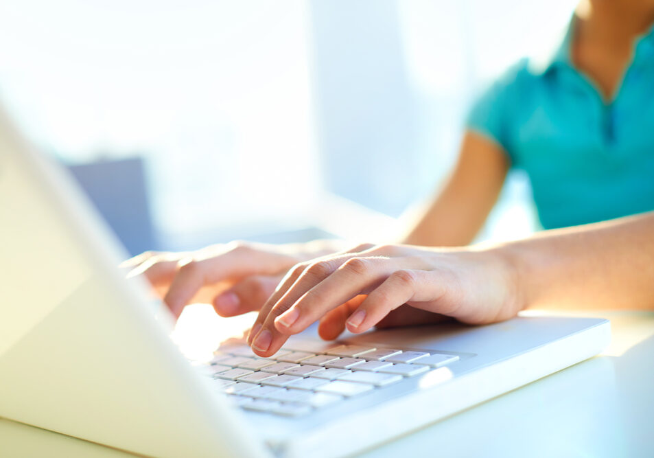 Close-up shot of a female learner typing on the laptop keyboard